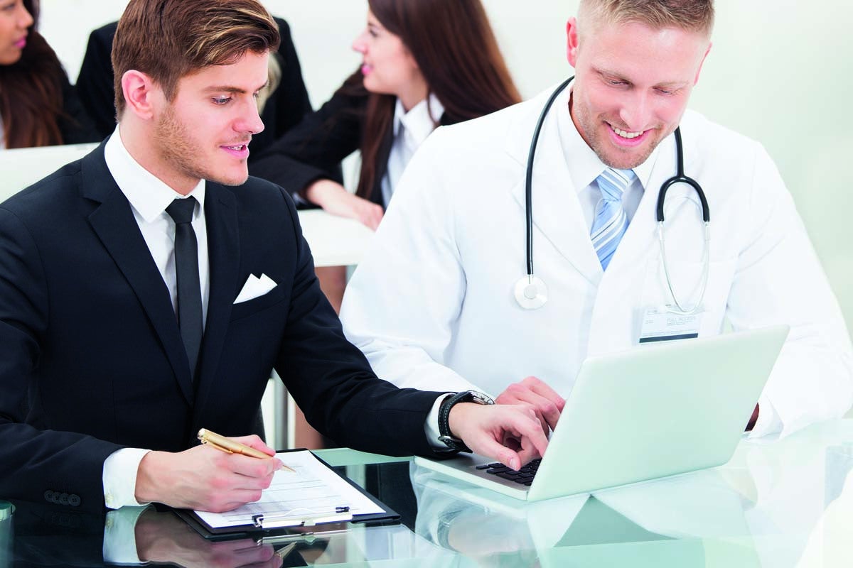 Doctor And Businessman Discussing Over Laptop